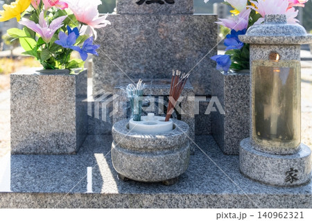 お盆 線香を灯したお墓の香炉と供花 お盆 線香を灯したお墓の香炉と供花 140962321