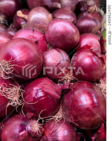 Fresh red onions displayed at a local market in early morning light Fresh red onions displayed at a local market in early morning light 140962495