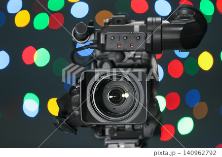 Modern video camera against blurred colorful lights Modern video camera against blurred colorful lights 140962792