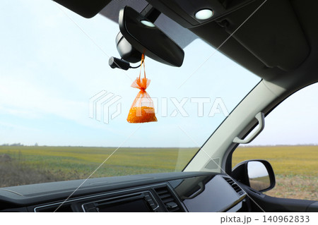 Air freshener hanging on rear view mirror in car Air freshener hanging on rear view mirror in car 140962833