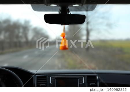 Air freshener hanging on rear view mirror in car Air freshener hanging on rear view mirror in car 140962835