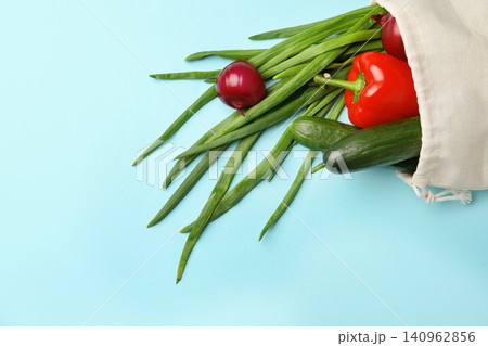 Cotton eco bag with vegetables on light blue background, top view Cotton eco bag with vegetables on light blue background, top view 140962856