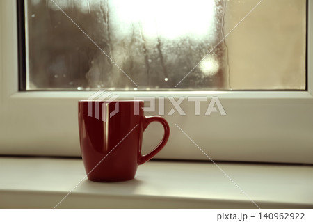 Cup of hot drink near window on rainy day. Space for text Cup of hot drink near window on rainy day. Space for text 140962922