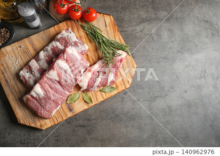 Raw ribs with herbs and spices on grey table, flat lay. Space for text Raw ribs with herbs and spices on grey table, flat lay. Space for text 140962976