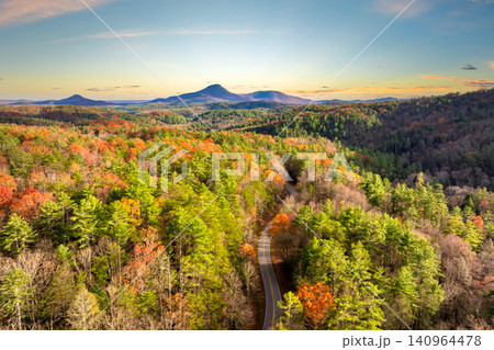 Winding forest road in Tennessee Appalachians during fall. Car traveling through mountain woods under glowing autumn leaves 140964478