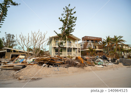 Consequences of natural disaster. Trash from severely damaged houses after hurricane Milton storm surge. Piles of debris on street side on Manasota key street in Florida Consequences of natural disaster. Trash from severely damaged houses after hurricane Milton storm surge. Piles of debris on street side on Manasota key street in Florida 140964525