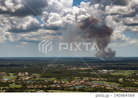 Prescribed fire smoke rising up over suburban neighborhood in Florida 140964569