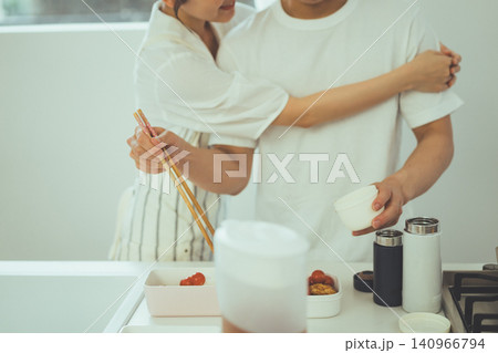 弁当作り中にキッチンで男性に腕を回して寄り添うカップルの顔なしショット 弁当作り中にキッチンで男性に腕を回して寄り添うカップルの顔なしショット 140966794
