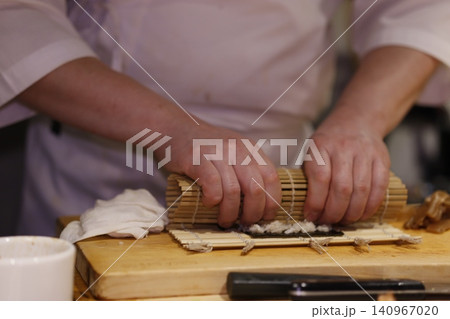 Chef Making Sushi with Bamboo Mat 140967020