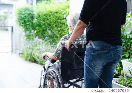 Caregiver help Asian elderly woman disability patient sitting on wheelchair in hospital. Caregiver help Asian elderly woman disability patient sitting on wheelchair in hospital. 140967089