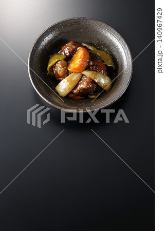 人参、玉ねぎ、ピーマン、肩ロース肉の入った黒酢酢豚を黒背景で単品撮影 人参、玉ねぎ、ピーマン、肩ロース肉の入った黒酢酢豚を黒背景で単品撮影 140967429
