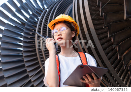 Young Asian engineer teen woman working service power plant turbine fan blade electrical generator Young Asian engineer teen woman working service power plant turbine fan blade electrical generator 140967533