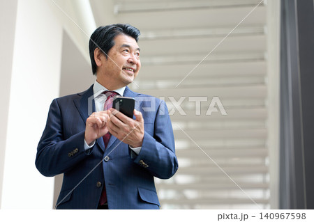 スマートフォンを操作するアジア人ビジネスマン スマートフォンを操作するアジア人ビジネスマン 140967598