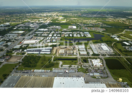 High angle view of big commercial shipping center with many freight trucks unloading and uploading goods for further distribution. Global economy concept High angle view of big commercial shipping center with many freight trucks unloading and uploading goods for further distribution. Global economy concept 140968103