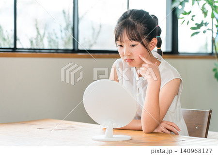 鏡を見る肌荒れ,ニキビに悩む小学生,中学生の女の子 鏡を見る肌荒れ,ニキビに悩む小学生,中学生の女の子 140968127