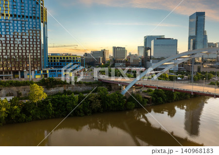 Nashville, big city in Tennessee at sunset. Downtown skyscrapers rise above riverfront with bridge and warm sundown glow over metropolitan skyline Nashville, big city in Tennessee at sunset. Downtown skyscrapers rise above riverfront with bridge and warm sundown glow over metropolitan skyline 140968183