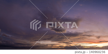 Bright sunset with setting sun behind vivid orange and yellow clouds Bright sunset with setting sun behind vivid orange and yellow clouds 140968236