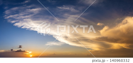 Colorful sunset sky with setting sun behind vivid orange and yellow clouds Colorful sunset sky with setting sun behind vivid orange and yellow clouds 140968332