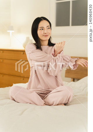 ベッドの上でストレッチをする若い女性 ビューティイメージ ベッドの上でストレッチをする若い女性 ビューティイメージ 140968430