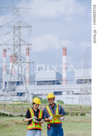 Electricity engineer working team against power plant background and power line survey inspector Electricity engineer working team against power plant background and power line survey inspector 140968558