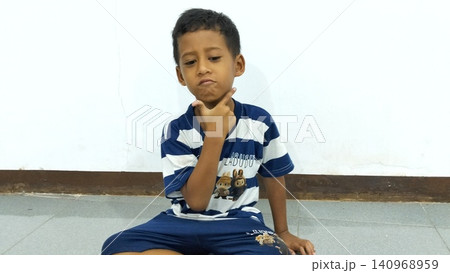 Determined Young Boy Raising His Fist with Serious Gaze Determined Young Boy Raising His Fist with Serious Gaze 140968959