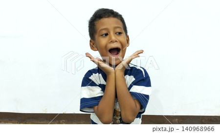 Determined Young Boy Raising His Fist with Serious Gaze 140968966