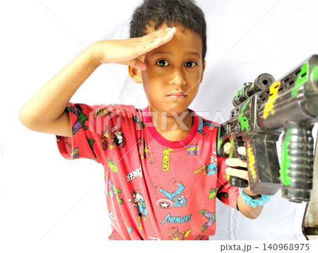 Determined Young Boy Raising His Fist with Serious Gaze 140968975
