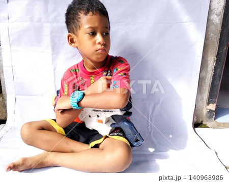 Determined Young Boy Raising His Fist with Serious Gaze Determined Young Boy Raising His Fist with Serious Gaze 140968986