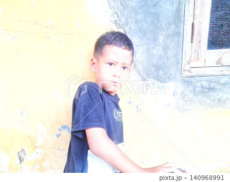 Determined Young Boy Raising His Fist with Serious Gaze 140968991