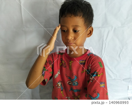 Determined Young Boy Raising His Fist with Serious Gaze Determined Young Boy Raising His Fist with Serious Gaze 140968993