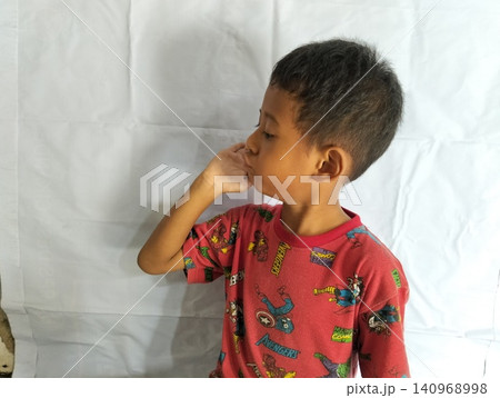 Determined Young Boy Raising His Fist with Serious Gaze Determined Young Boy Raising His Fist with Serious Gaze 140968998