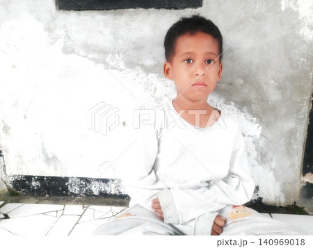 Determined Young Boy Raising His Fist with Serious Gaze Determined Young Boy Raising His Fist with Serious Gaze 140969018