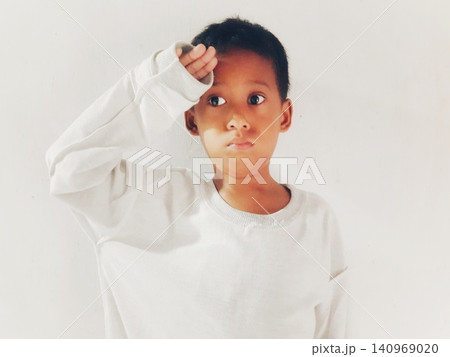 Determined Young Boy Raising His Fist with Serious Gaze Determined Young Boy Raising His Fist with Serious Gaze 140969020