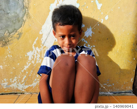 Determined Young Boy Raising His Fist with Serious Gaze 140969041