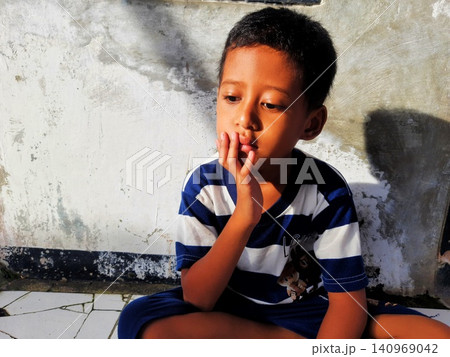 Determined Young Boy Raising His Fist with Serious Gaze 140969042