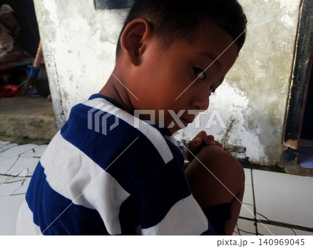 Determined Young Boy Raising His Fist with Serious Gaze 140969045