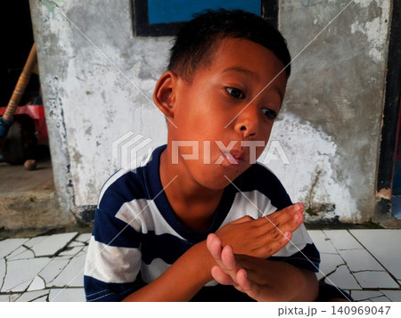 Determined Young Boy Raising His Fist with Serious Gaze Determined Young Boy Raising His Fist with Serious Gaze 140969047