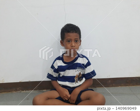 Determined Young Boy Raising His Fist with Serious Gaze Determined Young Boy Raising His Fist with Serious Gaze 140969049