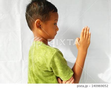 Determined Young Boy Raising His Fist with Serious Gaze Determined Young Boy Raising His Fist with Serious Gaze 140969052