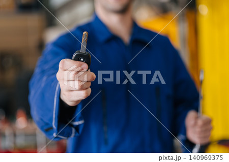 Mechanic technician male in car service center, Garage auto workshop hand showing car key. Mechanic technician male in car service center, Garage auto workshop hand showing car key. 140969375