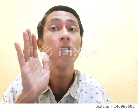 Young Asian Man Feeling Stressed with Headache Against Yellow Wall 140969603