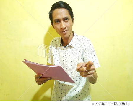 Young Asian Man Feeling Stressed with Headache Against Yellow Wall Young Asian Man Feeling Stressed with Headache Against Yellow Wall 140969619