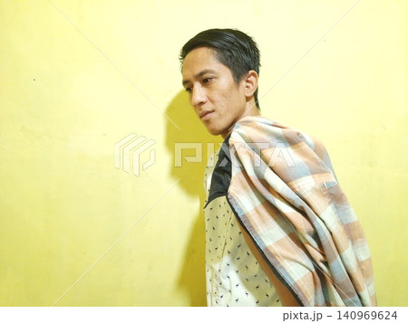 Young Asian Man Feeling Stressed with Headache Against Yellow Wall Young Asian Man Feeling Stressed with Headache Against Yellow Wall 140969624