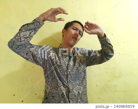 Energetic Asian Man in Batik Showing Hands with Surprised Expression Energetic Asian Man in Batik Showing Hands with Surprised Expression 140969859