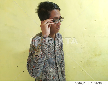 Energetic Asian Man in Batik Showing Hands with Surprised Expression Energetic Asian Man in Batik Showing Hands with Surprised Expression 140969862