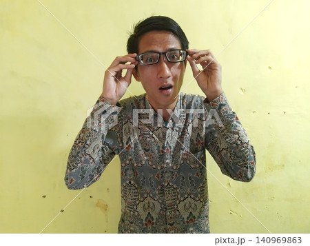 Energetic Asian Man in Batik Showing Hands with Surprised Expression Energetic Asian Man in Batik Showing Hands with Surprised Expression 140969863