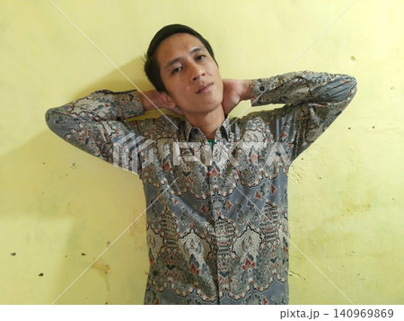 Energetic Asian Man in Batik Showing Hands with Surprised Expression 140969869
