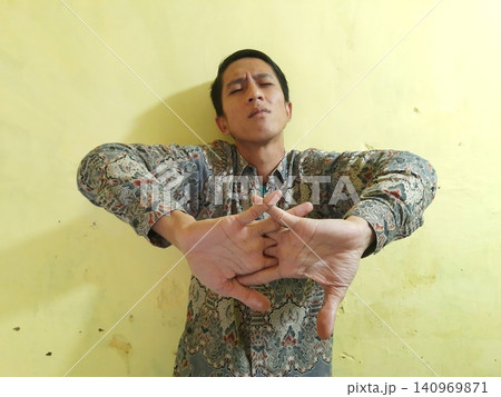 Energetic Asian Man in Batik Showing Hands with Surprised Expression Energetic Asian Man in Batik Showing Hands with Surprised Expression 140969871