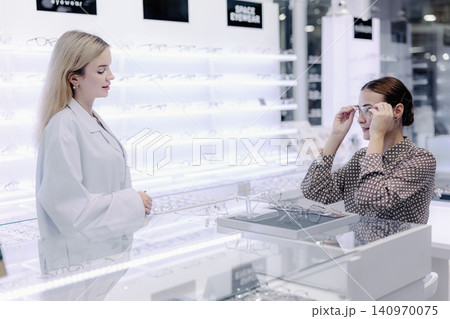 Optical store, Glasses shop staff service customer eyeglasses, Professional eyewear consultation Optical store, Glasses shop staff service customer eyeglasses, Professional eyewear consultation 140970075
