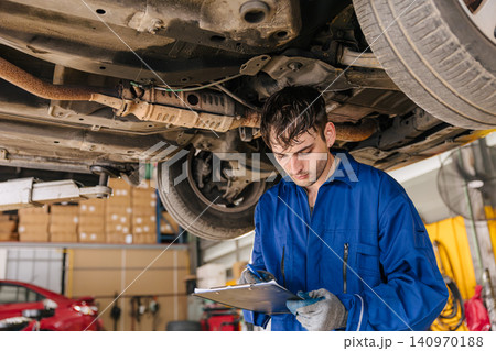 Garage Mechanic worker in auto service center working steering brake service maintenance under car. 140970188